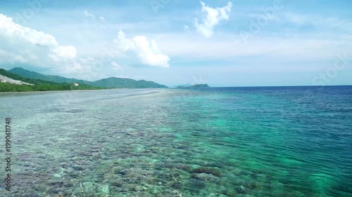 Aerial View of Tropical Coastline with Crystal Clear Turquoise Water, Coral Reef, and Lush Green Mountains - 4K footage