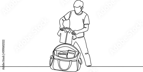 Man packing travel bag with clothes.