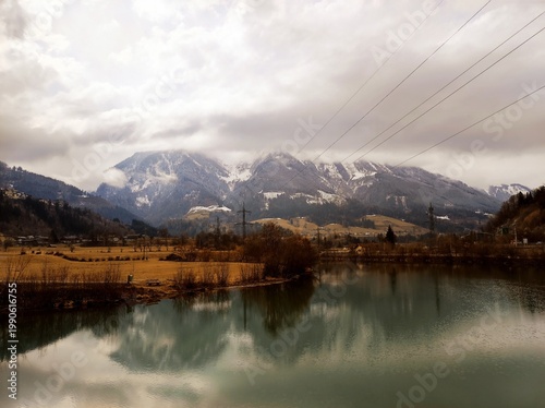 Winter mountain landscape with river and cloudy sky in St. Johann im Pongau, Austria