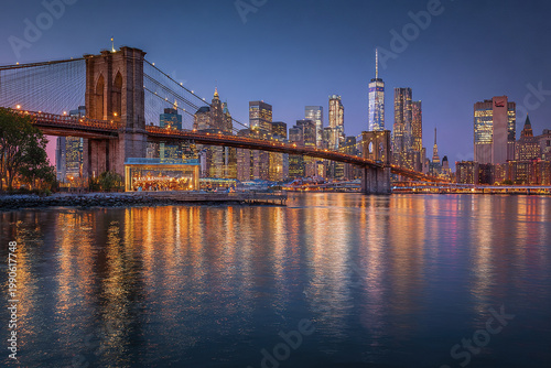 Panoramic view of illuminated suspension bridge and city skyline reflecting on calm water during twilight with clear sky and vibrant urban lights creating peaceful atmosphere