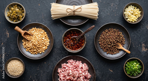 Top down view of Dan Dan Noodles ingredients on dark matte ceramic