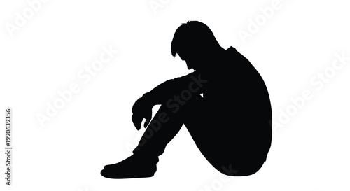 A solitary figure sits huddled in a seated position a striking silhouette