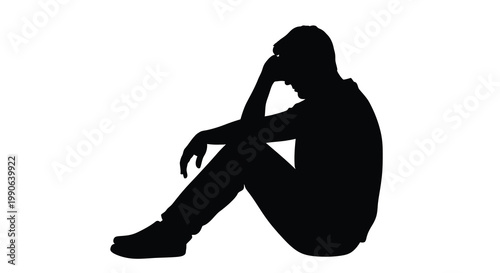 A solitary man sits in despair head in hands a poignant silhouette