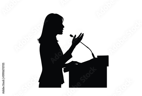 A woman giving a speech at a podium captured in stark silhouette