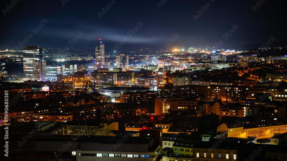 Obraz premium Night photography of the city of Brno - Czech Republic - Europe. Landscape with buildings and lights in the evening. View of buildings in the city. AZ Tower the tallest building in the Czech Republic.