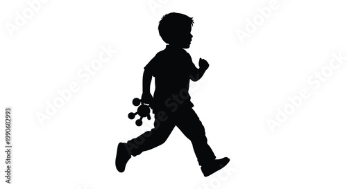 A young boy runs and plays with a toy captured in dark silhouette