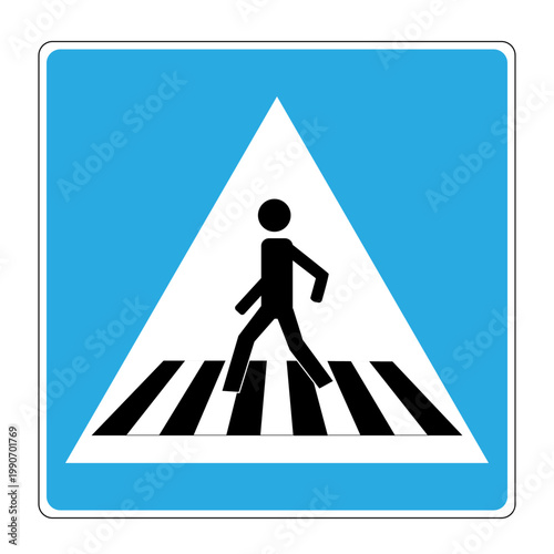 A man crosses the road at a pedestrian crossing sign