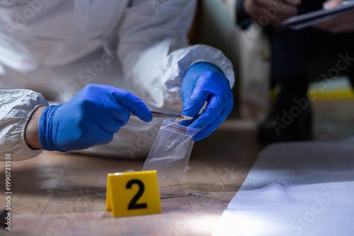 Cuadro en lienzo Forensic specialist in protective suit and blue gloves collecting evidence with