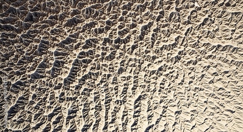 Aerial view of rugged terrain with intricate patterns of light and shadow