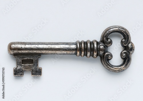 Ornate, antique metal key with a looped handle and intricate bit, isolated on white