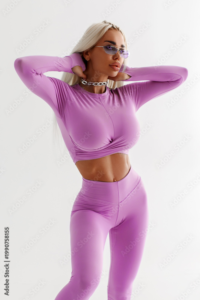 Fototapeta premium Beautiful woman in leggings on the gray background. Athletic girl