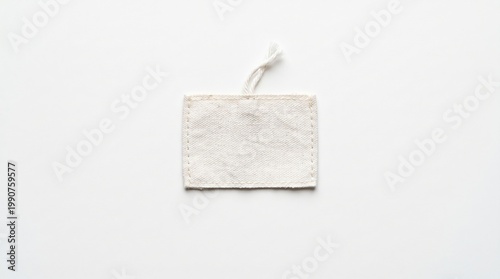 Blank fabric price tag on white background. Minimal cotton label with string for product mockup, textile branding, packaging detail, retail design and copy space