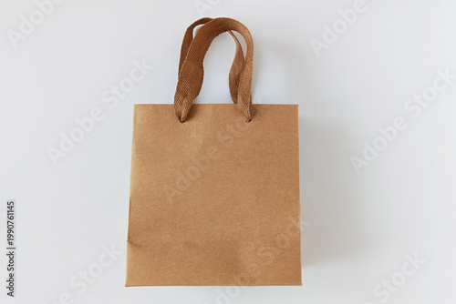 Kraft paper bag with handles. White background.