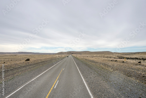 Foto lone biker on road 5 straight in Argentinian steppe near Estancia Las Vegas, San