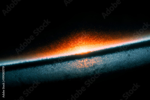 Abstract close-up of a vibrant orange and blue textured surface with a dramatic light effect.