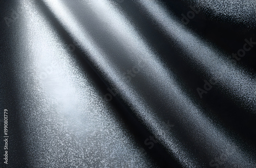 Abstract dark gray fabric background with elegant folds and soft light reflections, creating a luxurious and textured surface.