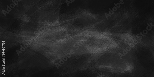 Dark gray scratched dusty and grunge chalkboard background texture with white smudges and blackboard surface