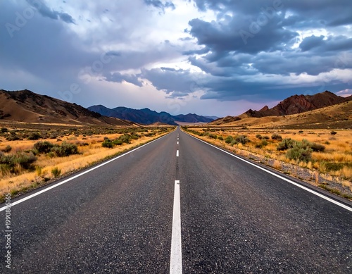 Straight Asphalt Highway Through Desert Mountains Under Dramatic Stormy With Dark Clouds At Sunset