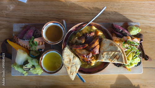 Gourmet Shared Platter With Grilled Meats, Pita Bread and Dips on Wooden Serving Board