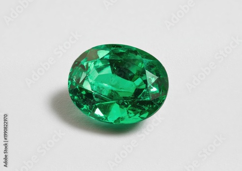 Oval-cut, vibrant green gemstone with brilliant facets, casting a soft shadow