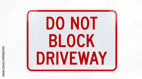 A red and white sign with the words 'DO NOT BLOCK DRIVEWAY' on a plain background