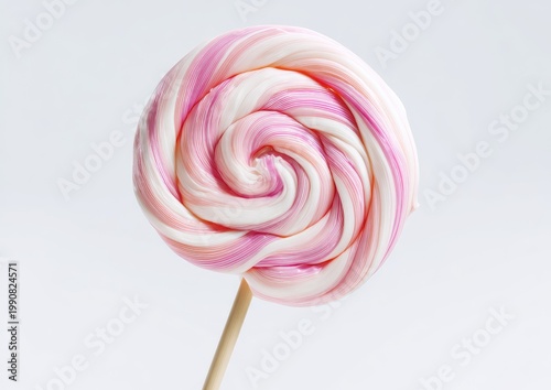 Swirled pink and white lollipop on a wooden stick against a light backdrop