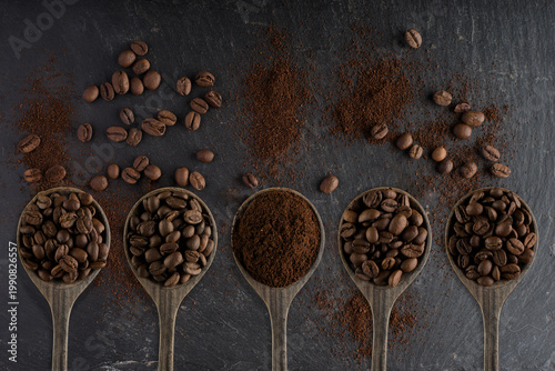 Composition avec des grains de café et du café moulu dans des cuillers en bois sur un fond en ardoise