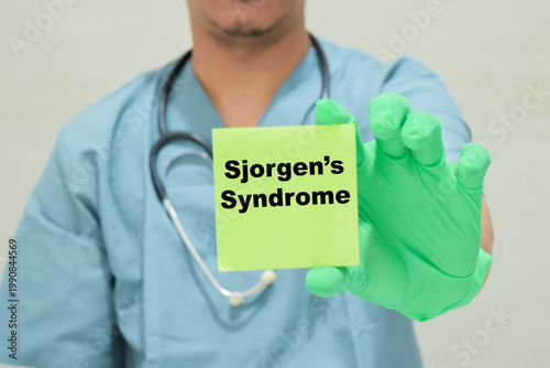 Doctor holds in hands a card with the name of the Sjogren's syndrome. Medical concept