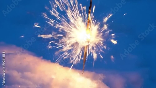 Sparkler creating bright sparks against a blue winter background  