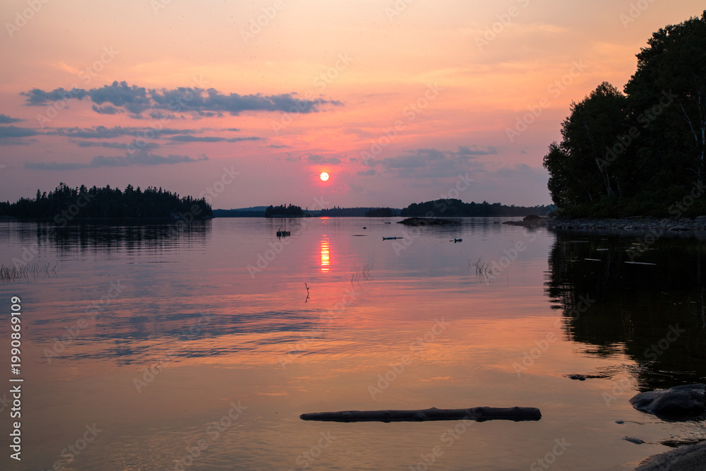 Obraz premium Sunset over calm lake in La Verendrye Wildlife Reserve Quebec with reflection