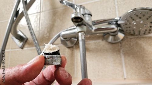 Φωτογραφία Limescale buildup in faucet aerator, hard water calcium deposits clogging tap fi