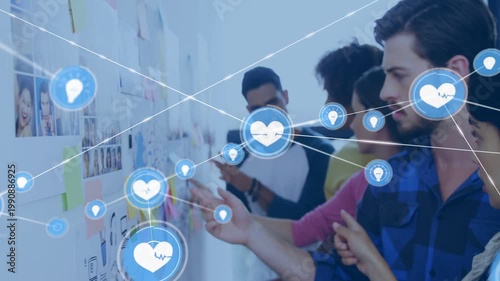 Designers adding stickies to wall while organizing ideas, animated hearts and bulbs linking notes