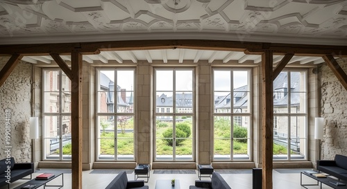 Modern lounge interior in a renovated historic building with wooden beams and large windows