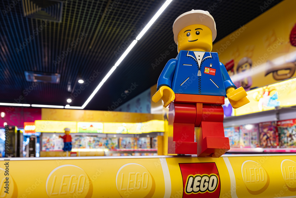 Fototapeta premium LEGO worker minifigure on yellow display shelf in store
