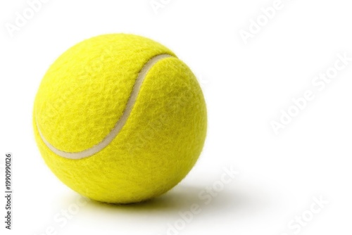 Vibrant yellow tennis ball photographed close up featuring copy space over white background