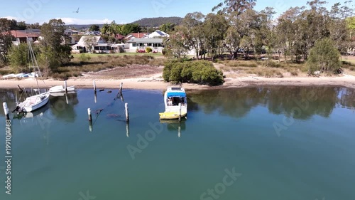 Aerial Drone Dronie of Couple on Boat Pulling Back to Reveal Coastal Homes and Bay View in Woy Woy, NSW, Australia