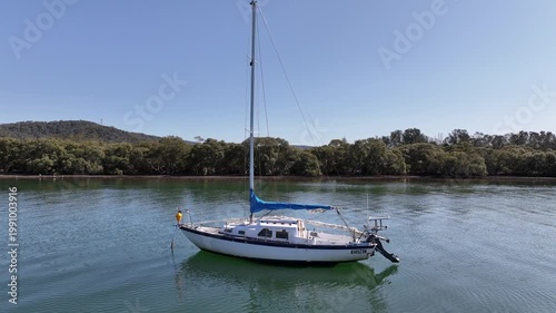 Aerial Drone Shot Flying Through Yacht Sails Toward Mangroves Over Blue Water in Woy Woy, NSW, Australia