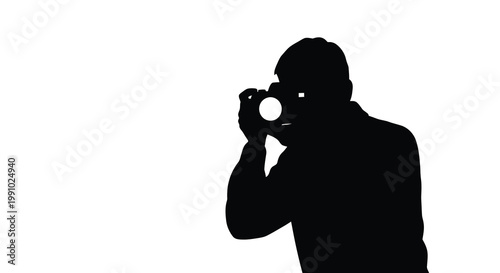 Silhouette of a photographer aiming a camera towards a bright light source