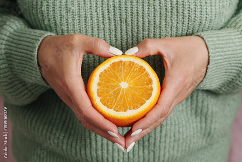 Foto Woman holds sliced orange fruit