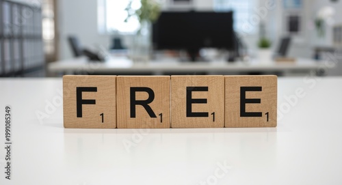 Wood blocks arranged to spell FREE on white office workspace