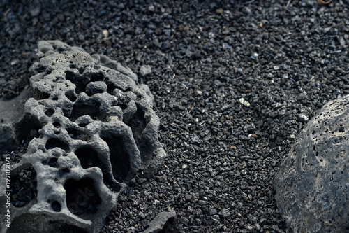 Photography Detailed view of porous volcanic rocks and black basalt gravel on the ground in Lanzarote