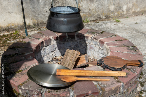 built-in fireplace in garden with cauldron and cooking utensils