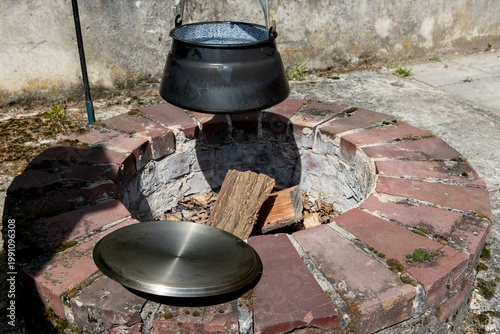 built-in fireplace in garden with cauldron and cooking utensils