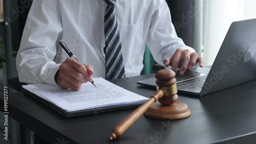 Lawyer working in office investigate the case by reading documents and using laptop.