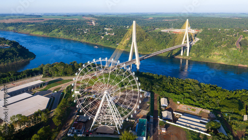 Bild auf Leinwand Wide aerial view of Foz do Iguaçu ferris wheel and Ponte da Integração over the Paraná River at the Triple Frontier