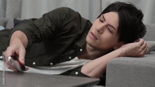 ソファで寝落ちする男性