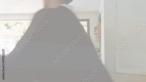 Graduates entering through paneled door, adjusting gowns on sofa, celebrating education and friends