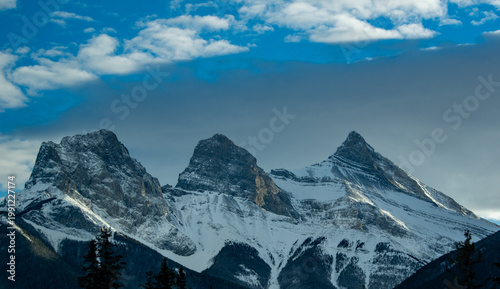 Three Sisters mountains by Canmore, Alberta, in golden evening light.