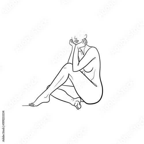 A woman sits cross-legged on the floor with her hand on her face.