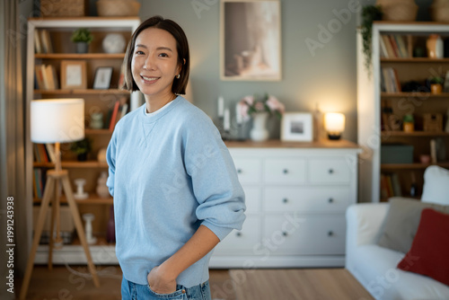 Foto Smiling asian woman relaxing in comfortable home living room